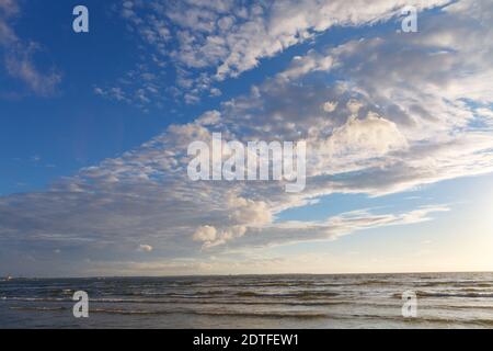 Sole splendente nei cieli blu sul mare Foto Stock