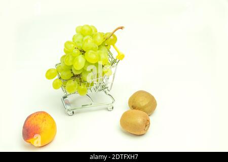 Uva e pesca con kiwi su sfondo isolato per il testo. Frutta su uno sfondo bianco isolato Foto Stock