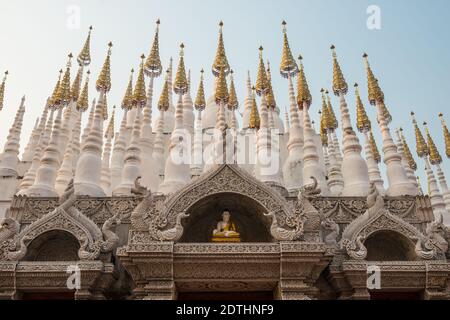 Una statua di Buddha sopra l'ingresso di un tempio buddista in Thailandia. Foto Stock