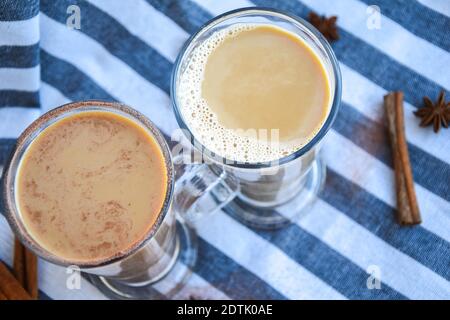 Caffè ghiacciato con latte in bicchieri alti, tazze di gustoso caffè frappe, latte machiato, due tazze di cappuccino con bastoncini di cannella e stelle di anice, adver Foto Stock