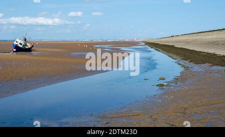 Meols, il Wirral, Regno Unito: 23 giugno 2020: Una piccola barca poggia sulla sabbia a bassa marea. Foto Stock