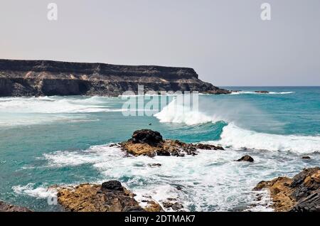 Spagna, Isole Canarie, Fuerteventura, costa e surfista a El Puerto de Los Molinos, Foto Stock