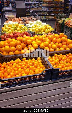 Tangerini, arance, mele e altri frutti sono venduti in negozio. Immagine verticale. Foto Stock