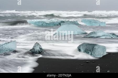 Iceberg sulla spiaggia vulcanica nera. Spiaggia dell'atlantico nord vicino alla laguna glaciale Joekulsarlon e ghiacciaio Breithamerkurjoekull nel Vatnajoeku Foto Stock