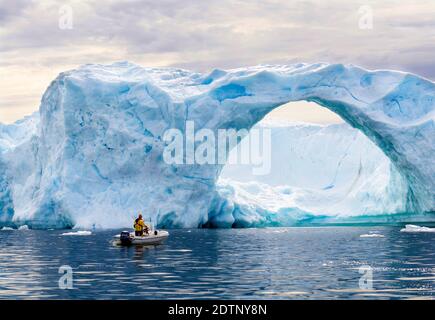 Iceberg nella baia di Disko, cacciatore locale a caccia di foche in piccola barca. Groenlandia, Danimarca, agosto Foto Stock