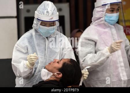 Giacarta, Indonesia. 22 dicembre 2020. Un operatore sanitario prende un campione di tampone nasale di un passeggero del treno per testare la COVID-19 alla stazione ferroviaria di Pasar Senen a Giacarta, Indonesia, il 22 dicembre 2020. I casi COVID-19 in Indonesia sono saliti di 6,347 nelle ultime 24 ore a 678,125, con il numero di morti che si aggiunge da 172 a 20,257, ha detto il Ministero della Salute Martedì. Credit: Agung Kuncahya B./Xinhua/Alamy Live News Foto Stock