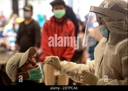 Giacarta, Indonesia. 22 dicembre 2020. Un operatore sanitario prende un campione di tampone nasale di un passeggero del treno per testare la COVID-19 alla stazione ferroviaria di Pasar Senen a Giacarta, Indonesia, il 22 dicembre 2020. I casi COVID-19 in Indonesia sono saliti di 6,347 nelle ultime 24 ore a 678,125, con il numero di morti che si aggiunge da 172 a 20,257, ha detto il Ministero della Salute Martedì. Credit: Agung Kuncahya B./Xinhua/Alamy Live News Foto Stock