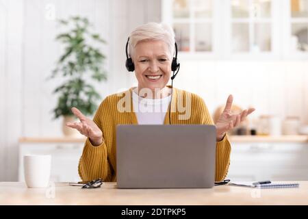 Felice vecchia donna che usa il computer portatile, con videochiamata Foto Stock
