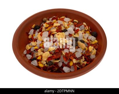 Vista laterale della stagionatura di aglio e peperoncino in una piccola ciotola di argilla isolata su sfondo bianco. Foto Stock