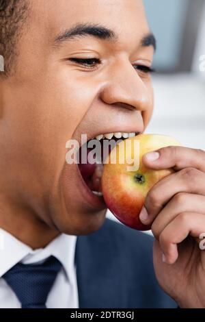 uomo d'affari afro-americano mordere la mela Foto Stock