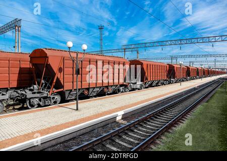 trasporto ferroviario trasporto di grano per il trasporto di colture agricole alla stazione in una giornata di sole, cargo con carico sfuse, nessuno. Foto Stock