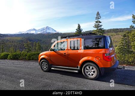 Un'auto a 4 ruote motrici su una strada in ghiaia di montagna nelle montagne Oregon Cascade vicino alla città di Sisters, Oregon. Foto Stock