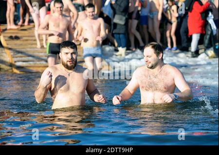 Due uomini che si tuffano in acqua ghiacciata durante la festa Epifania sul fiume Dnieper. 19 gennaio 2019. Kiev, Ucraina Foto Stock