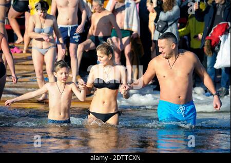 Uomo di famiglia donna e bambino immerso in acqua ghiacciata durante la festa Epifania sul fiume Dnieper. 19 gennaio 2019. Kiev, Ucraina Foto Stock