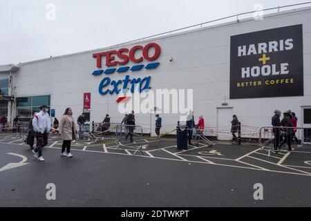 Watford, Regno Unito. 22 dicembre 2020. I clienti si accodano fuori dal superstore Tesco a Watford, Hertfordshire. La contea, così come gran parte del Regno Unito, è nel livello 4, rimanere a casa, livello di allarme come la pandemia di coronavirus continua e l'individuazione di un nuovo ceppo mutante sta mettendo pressione sul governo britannico per attuare un blocco nazionale. I timori di una mancanza di cibo fresco hanno iniziato ad acquistare panico in alcune zone. Credit: Stephen Chung / Alamy Live News Foto Stock