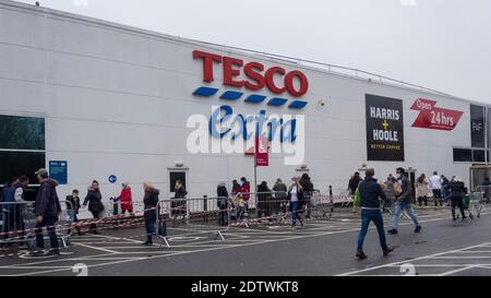 Watford, Regno Unito. 22 dicembre 2020. I clienti si accodano fuori dal superstore Tesco a Watford, Hertfordshire. La contea, così come gran parte del Regno Unito, è nel livello 4, rimanere a casa, livello di allarme come la pandemia di coronavirus continua e l'individuazione di un nuovo ceppo mutante sta mettendo pressione sul governo britannico per attuare un blocco nazionale. I timori di una mancanza di cibo fresco hanno iniziato ad acquistare panico in alcune zone. Credit: Stephen Chung / Alamy Live News Foto Stock