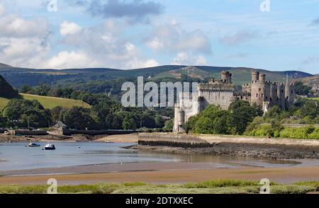 Il castello di Conwy circondato da colline e il fiume Conwy In Galles Foto Stock