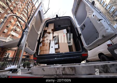 New York, Stati Uniti. 21 Dic 2020. Un autocarro a mano si trova dietro un camion FEDEX parcheggiato pieno di pacchi in attesa di essere consegnati a New York, NY, 21 dicembre 2020. Con una rinascita delle infezioni COVID-19, i servizi di spedizione dei pacchetti come FEDEX, UPS e USPS prevedono di fornire un numero record di pacchetti per il 2020. (Foto di Anthony Behar/Sipa USA) Credit: Sipa USA/Alamy Live News Foto Stock