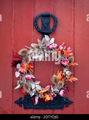 Corona d'autunno stagionale su una porta d'ingresso Red Front, Cheshire, Inghilterra, Regno Unito Foto Stock