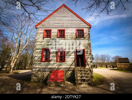 Casa in legno vecchio stile con finestre rosse e porta aperta nel villaggio Foto Stock