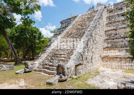 Scalini di pietra e teste di serpente piume sulla piramide di Osario (Tempio dell'Alto sacerdote), Chichen Itza, città maya e sito archeologico, Yucatan, Messico Foto Stock