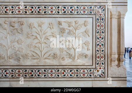 Dettagli decorativi di motivi vegetali e pietra dura intarsiato su un muro del iconico Taj Mahal, tomba mausoleo di Mumtaz Mahal, Agra, Uttar Pradesh, India Foto Stock