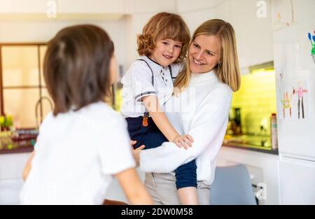 Madre e i suoi figli in cucina Foto Stock