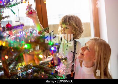 Madre e figlio decorare albero di Natale Foto Stock