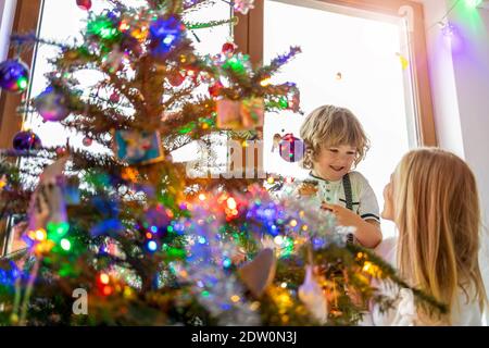Madre e figlio decorare albero di Natale Foto Stock