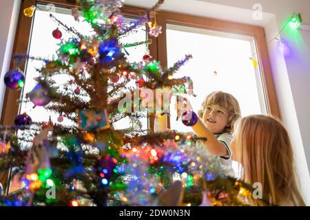 Madre e figlio decorare albero di Natale Foto Stock