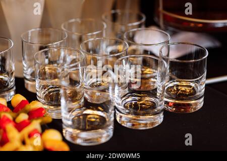 Occhiali con il cognac, whiskey stand sulla barra. un sacco di occhiali con il cognac. Il consumo di alcol nei bicchieri. Varie bevande alcoliche permanente sulla barra. bicchieri w Foto Stock
