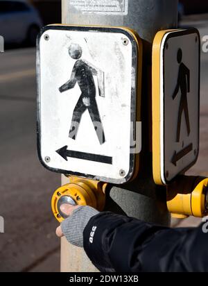 Una donna attiva un segnale di attraversamento pedonale in corrispondenza di un incrocio a Santa Fe, New Mexico. Foto Stock