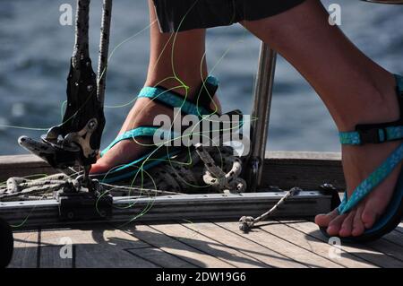 Una linea per la pesca sul ponte di uno yacht a vela illuminato dalla luce del sole. Foto Stock