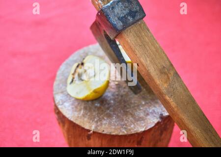 Tagliare la cotogna per mezzo di assi. Tutti rimangono su legno con sfondo rosso tappeto. Foto Stock