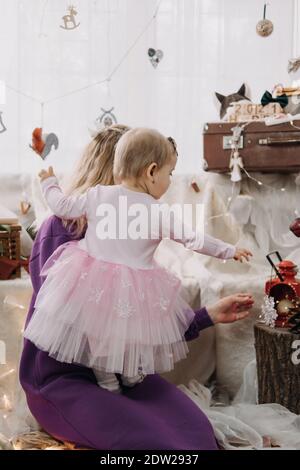Giornata di pugilato, giorno di San Nicola. Bambina e mamma scompattato scatole con regali in decorazioni albero di Natale a casa. Buon Natale e un Felice nuovo Foto Stock