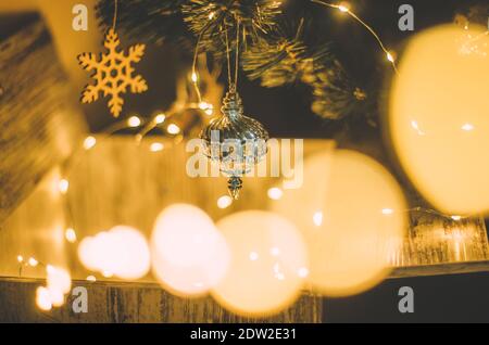 Luci natalizie calde e lussuose con appeso ornamento in argento dall'albero su una cassa magica aperta Foto Stock