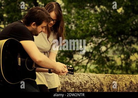 Fratello insegnava a suonare la chitarra in natura Foto Stock