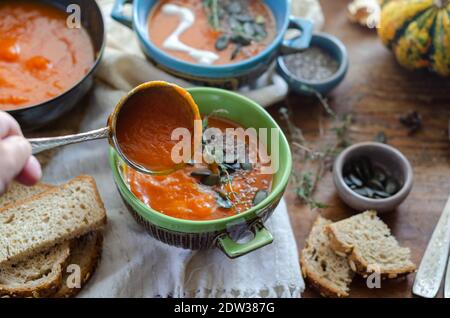 Zuppa di zucca autunnale con semi di zucca e chia , sparata da un tavolo rustico in legno Foto Stock