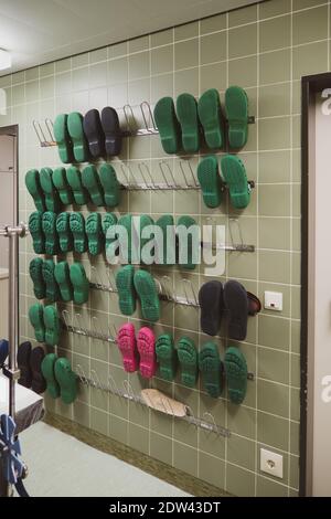 su un corridoio di sala operatoria c'è una parete con scarpe chirurgiche per il personale Foto Stock
