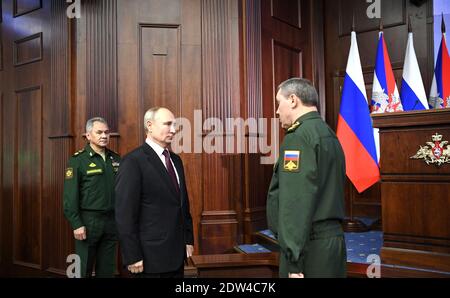 Mosca, Russia. 21 Dic 2020. Il presidente russo Vladimir Putin saluta il capo dello Stato maggiore delle forze armate russe Valery Gerasimov, a destra, mentre il ministro della Difesa Sergei Shoigu, a sinistra, guarda prima dell'incontro allargato del Consiglio del Ministero della Difesa al Centro Nazionale di controllo della Difesa 21 dicembre 2020 a Mosca, Russia. Credit: Planetpix/Alamy Live News Foto Stock