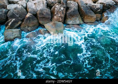 Tidewater Green mare o oceano acqua con schiuma sulla costa tropicale in pietra come sfondo di design alla moda. Foto Stock