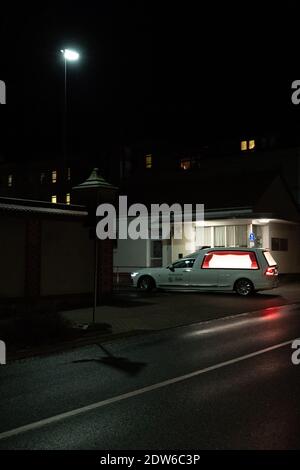 Zittau, Germania. 22 dicembre 2020. Un hearse guida nel viale del Klinikum Oberlausitz Bergland in serata. A causa del drammatico tasso di mortalità per corona a Zittau, nella Sassonia orientale, i cadaveri devono essere temporaneamente immagazzinati al di fuori del crematorio. Credit: Daniel Schäfer/dpa-Zentralbild/dpa/Alamy Live News Foto Stock