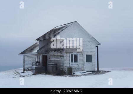 vecchia casa di legno sulla cima di una montagna in un neve inverno deserto paesaggio Foto Stock