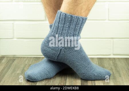 Calzini fatti a mano, caldo e fai-da-te calzini a maglia primo piano. Foto delle gambe maschili in primo piano con calzini a maglia. Idea di affari, guadagnando i soldi per un hobby Foto Stock