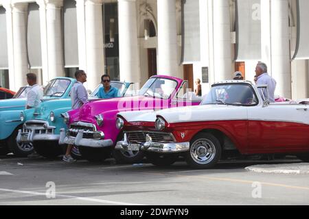 Fila di auto d'epoca americane dai colori vivaci parcheggiate La strada di fronte al Palazzo Galiziano sul Prado Via nel centro di Havana Cuba Foto Stock