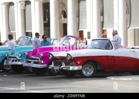 Fila di auto d'epoca americane dai colori vivaci parcheggiate La strada di fronte al Palazzo Galiziano sul Prado Via nel centro di Havana Cuba Foto Stock