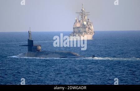 Foto dell'handout del 21 dicembre 2020 del sottomarino missilistico guidato USS Georgia (SSGN 729) di classe Ohio, transiti con l'incrociatore missilistico guidato USS Port Royal di classe Ticonderoga (CG 73) e l'incrociatore missilistico guidato USS Philippine Sea di classe Ticonderoga (CG 58), non mostrati, Sullo stretto di HormuzLa Marina statunitense sembra inviare un messaggio in Iran sotto forma di sottomarino missilistico guidato dotato di tremende forze d'artificio e forse di truppe speciali. Il sottomarino missilistico guidato USS Georgia di classe Ohio ha navigato nel Golfo Persico lunedì. Per la prima volta in otto anni, il Na Foto Stock