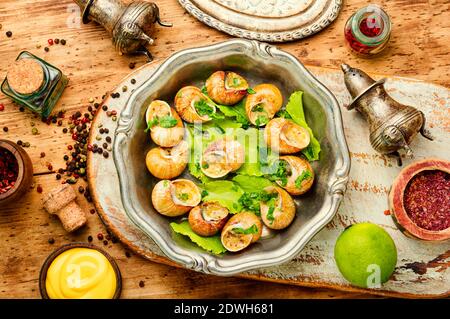 Lumache o escargot con burro all'aglio e lumache cotte al lime Foto Stock