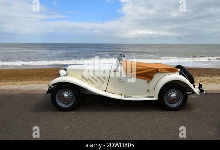 Auto classica Whie MG parcheggiata sul lungomare con spiaggia e mare sullo sfondo. Foto Stock