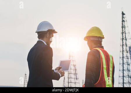 Project manager che gestisce la comunicazione tablet con Construction Engineering per il lavoro costruzione di immobili Foto Stock